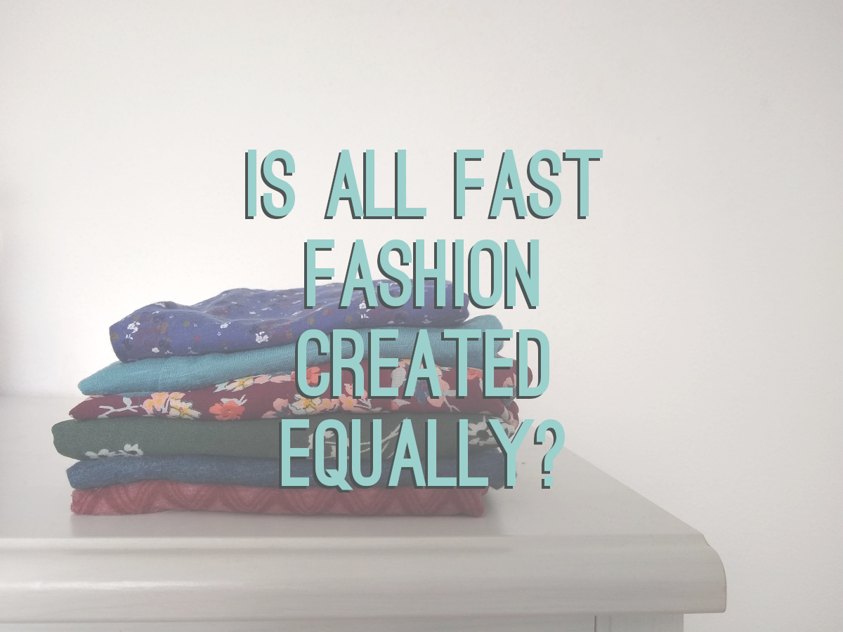 The text "Is all fast fashion created equally?" in turquoise with grey shadow on a photo background of a folded pile of colorful clothes on a white surface.